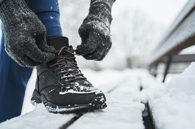 a close up of a person tying their laces on their snow boots