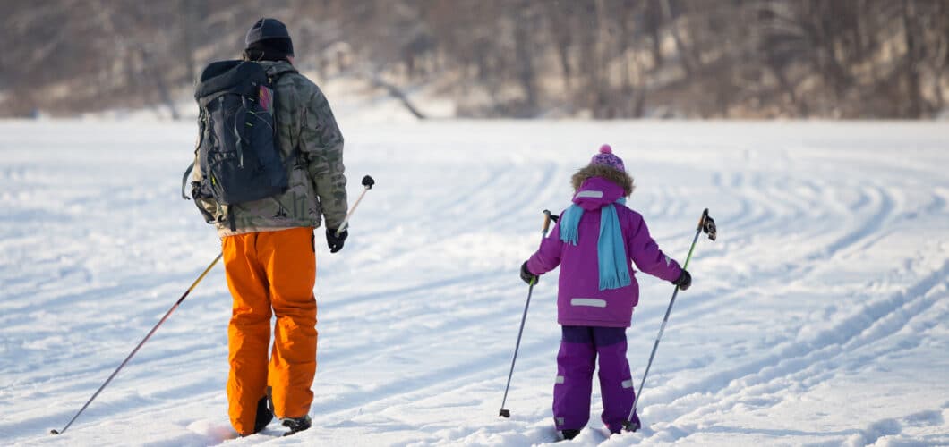 Man and little girl cross country skiing