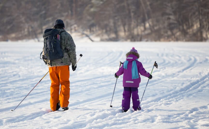 Man and little girl cross country skiing