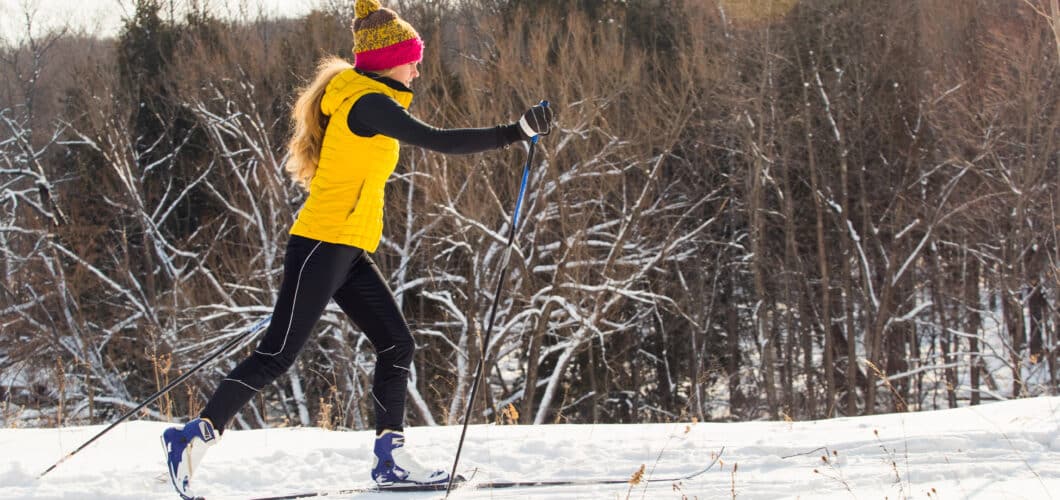 Young woman in yellow jacket cross countryskiing