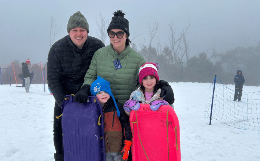 family in the snow with toboggans