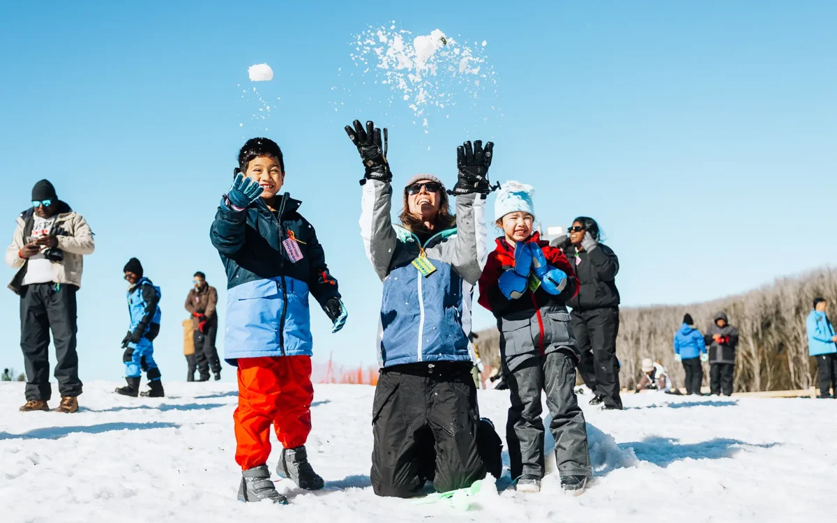 woman and two children playing with snow